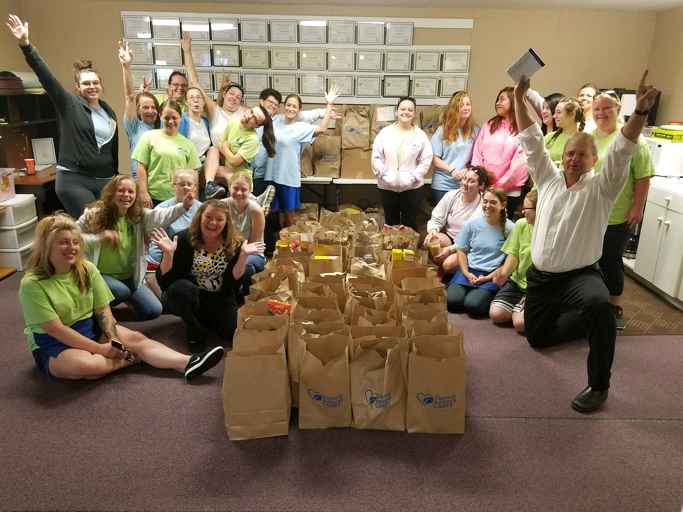 The TCA Dayton team poses with the food donations collected for local charities.